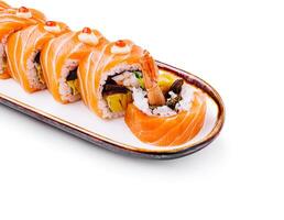 Freshly prepared salmon sushi roll served on a rectangular plate photo