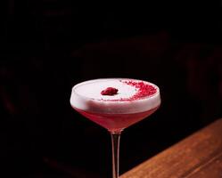 Raspberry cocktail in an elegant glass under soft lighting photo