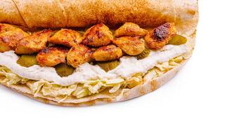 Grilled chicken wrap with creamy sauce and pickles on flatbread photo