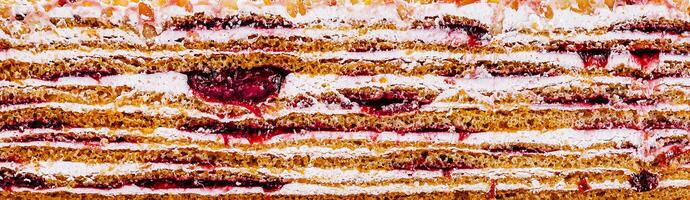 Delicious layers of cake with berry filling and cream icing photo