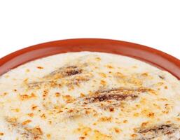 Delicious meat dish with cheese crust being served on plate photo