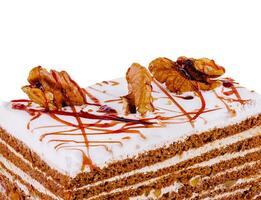 Delicious cake with walnuts and caramel drizzle on white background photo