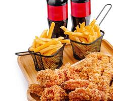 Enjoying crispy fried chicken with fries and soft drinks on a table photo