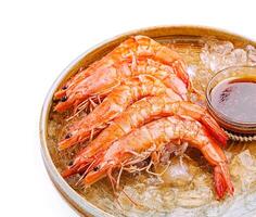 Freshly cooked shrimp served over ice with dipping sauce photo