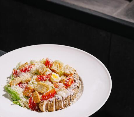 Fresh salad with tomatoes and croutons served in a modern restaurant