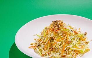 Fresh vegetable salad with walnuts on a green background photo