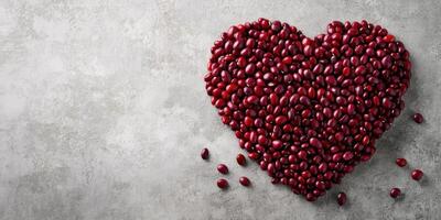 Red kidney beans arranged in a heart shape on a textured gray surface, symbolizing love for healthy eating and cooking photo