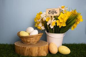 Easter card with yellow daffodil flowers in a bucket colorful eggs in a twigs basket photo