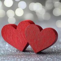 Two red wooden heart shapes on a sparkling silver background create a romantic and joyful atmosphere for special occasions photo