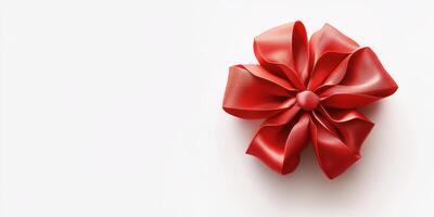 Red ribbon bow placed on a white surface, perfect for gift wrapping or decoration ideas during celebrations photo