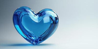 Beautiful blue glass heart sculpture reflecting light on a smooth surface photo