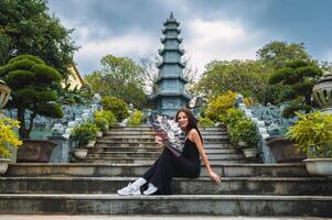 A female tourist on the background of the tower of the Buddhist temple in the Linh Un pagoda in Da Nang in Vietnam in Asia photo