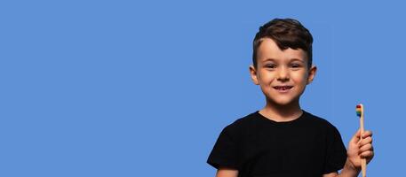 A cute boy with no front teeth. With a toothbrush in hand. Dental replacement and hygiene. Close-up. a place to copy photo