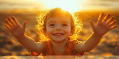 Happy child enjoying sunset on the beach while playing and reaching out with arms wide open photo