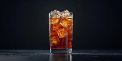Refreshing beverage served in a clear glass with ice cubes against a dark background photo
