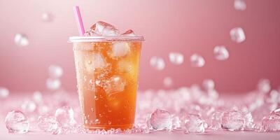 Refreshing iced beverage served in a clear cup with ice on a pink background photo
