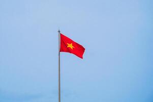 Vietnamese flag waving in the wind with clear blue sky. photo