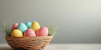 Colorful Easter eggs arranged in a woven basket surrounded by decorative grass on a light background photo