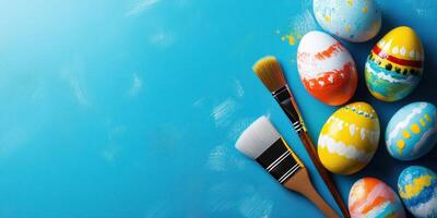 Colorful Easter eggs and painting supplies arranged on a bright blue background for festive decoration photo
