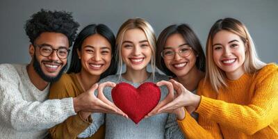 Group of friends smiling together while holding a red heart symbol in a warm indoor setting during daytime photo