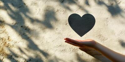 Hand reaching out to receive a symbol of love against a textured wall amid soft shadows photo