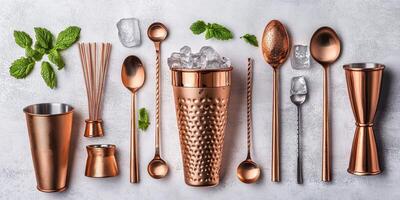 Stylish copper cocktail utensils arranged neatly with mint leaves and ice on a light background photo