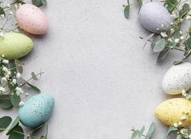 Easter eggs and eucalyptus leaves on gray background photo