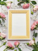 Empty frame with pink roses and eucalyptus on grey background photo