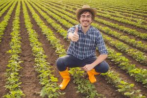 Happy farmer is satisfied with progress of plants. photo