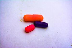 Red and yellow capsules and pills, representing various medications for health and wellness photo