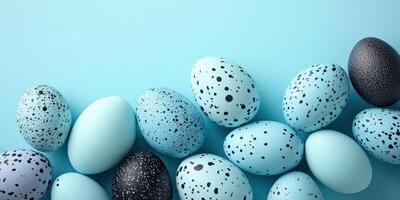 Colorful speckled eggs arranged on a pastel blue background for spring celebrations and decorations photo