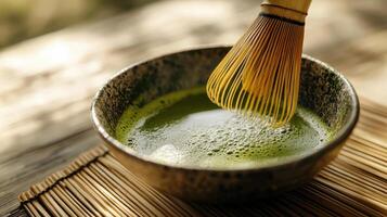 close up of matcha green tea preparation, showcasing whisk mixing vibrant green tea in bowl photo