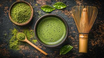 Fresh matcha green tea preparation with whisk, powder, and leaves photo