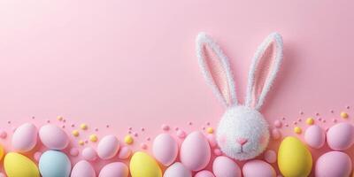 Celebration of Easter with pastel colored eggs and a fluffy bunny on a pink background inviting joy and festivity photo