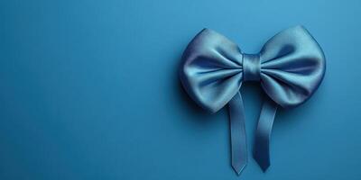 Elegant blue bow against a solid turquoise background for decorative purpose or gift wrapping photo