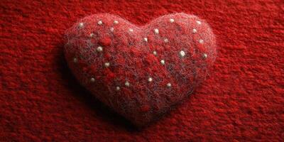 Soft red felt heart with white and silver embellishments resting on a textured red background photo