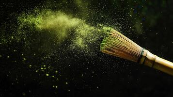 Bamboo whisk creating cloud of matcha tea powder on dark background, evoking sense of calm and tradition photo