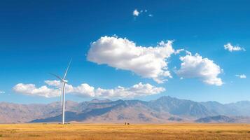 Wide angle view of wind turbine in vast landscape with mountains photo