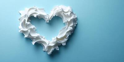 Creamy heart shape made of whipped topping on a light blue background for festive celebrations or desserts photo