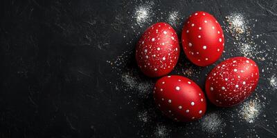 Colorful red eggs with white speckles arranged on a dark surface for festive celebration photo