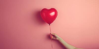 Heart-shaped balloon held against a soft pink background, symbolizing love and affection during a celebration or special occasion photo