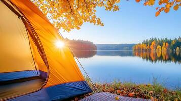 Cozy camping scene with tent and bag by a tranquil lake on a foggy autumn morning, surrounded by colorful fall foliage background photo