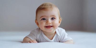 Baby smiling while playing on a soft surface during the day photo