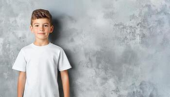 Smiling blond child boy in white t shirt mockup posing confidently during studio photoshoot neutral gray background Design template photo