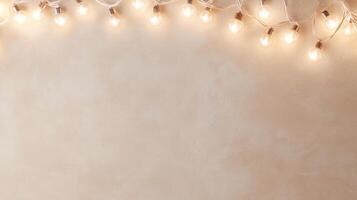 Lit christmas light bulbs hanging from a beige string against a pink wall create a warm, inviting atmosphere background Copy space for text photo