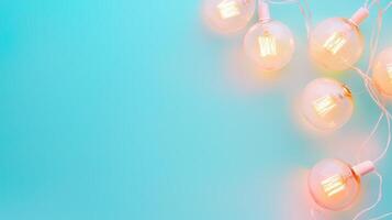 Glowing string lights hanging against turquoise background, casting soft warm illumination with open negative space for creative design placement Copy space for text photo