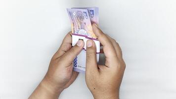 two hands counting Indonesian banknotes in the 10,000 rupiah denomination photo