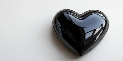 Heart-shaped black object placed on a light surface with reflections from nearby windows captured in an indoor setting photo