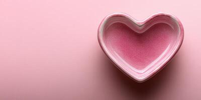 Heart-shaped ceramic bowl in soft pink color on a pastel background for decorative use and gifting ideas photo