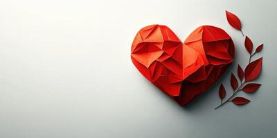 Creative red origami heart with leaf accents arranged on a simple background photo